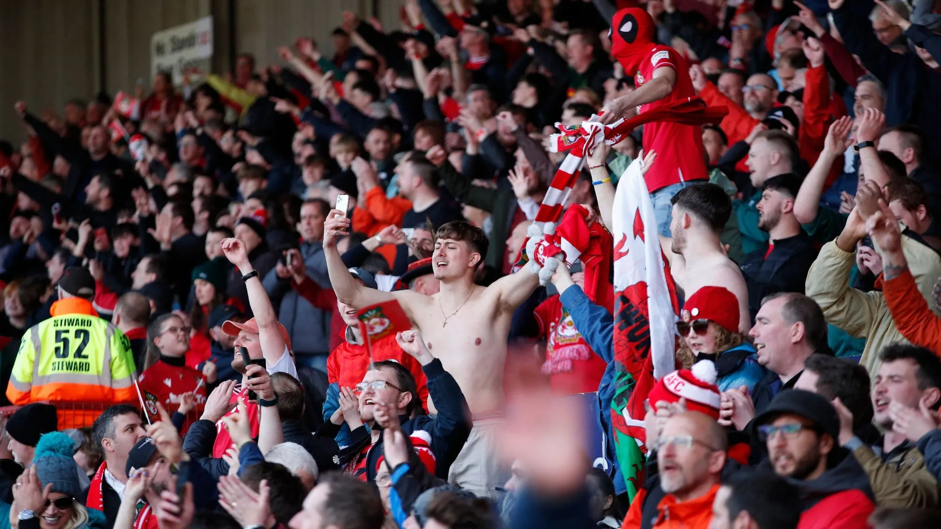 Người hâm mộ Wrexham cổ vũ trên khán đài sân Racecourse Ground
