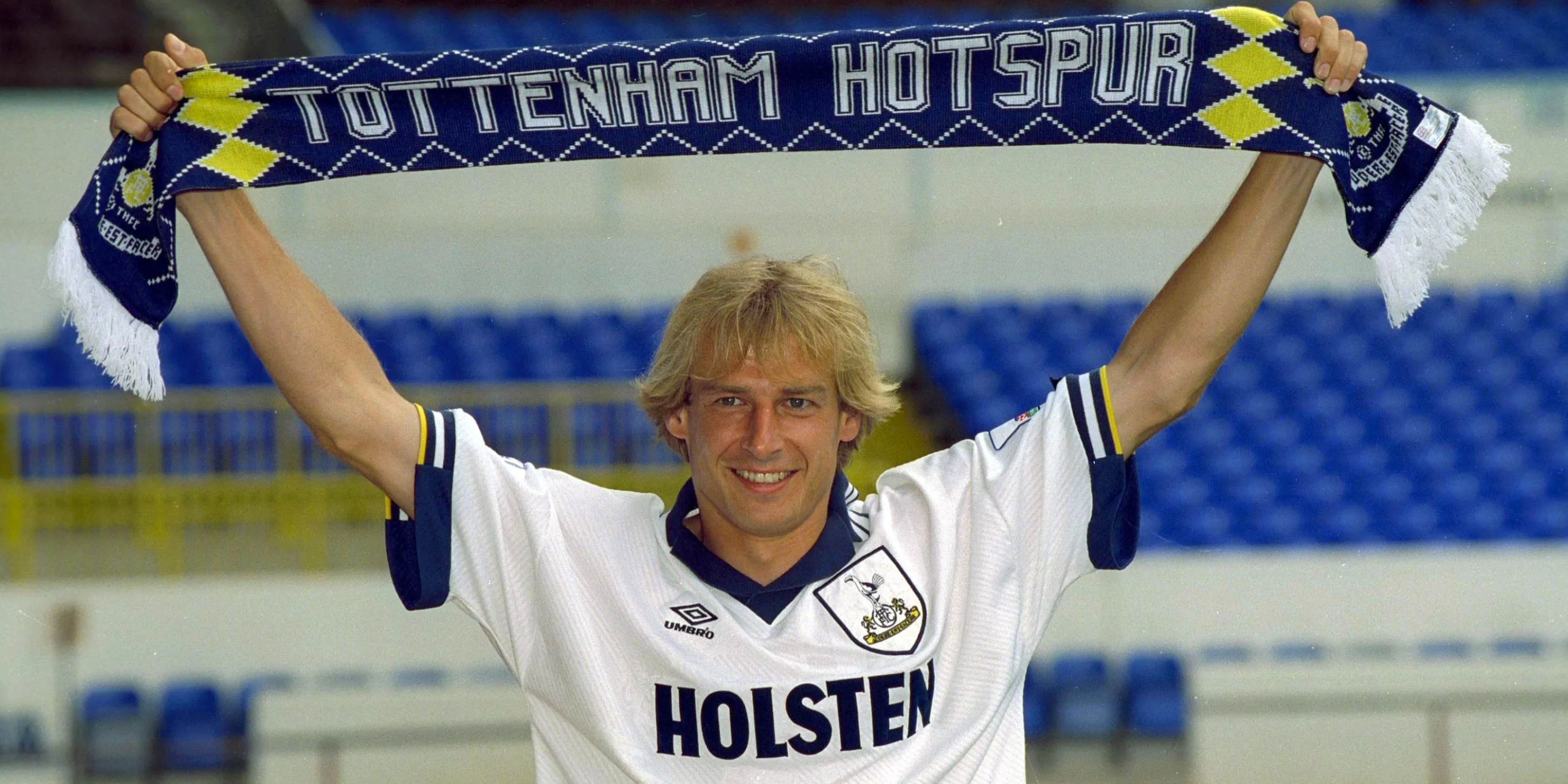 Jurgen Klinsmann giơ chiếc khăn của Tottenham sau khi ký hợp đồng với câu lạc bộ.